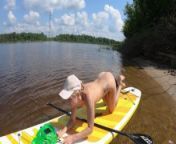 Naked girl on a SUP board on a big river from sport nudist